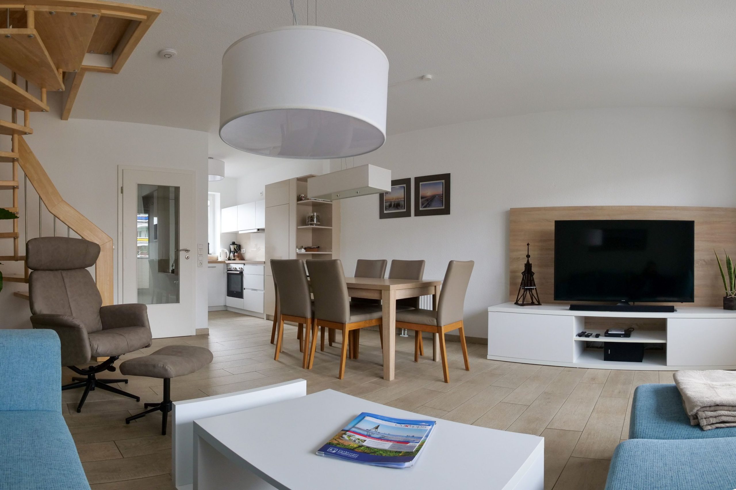 Sofa mit Fernseher und Essbereich und offene Küche in Ferienhaus in Cuxhaven