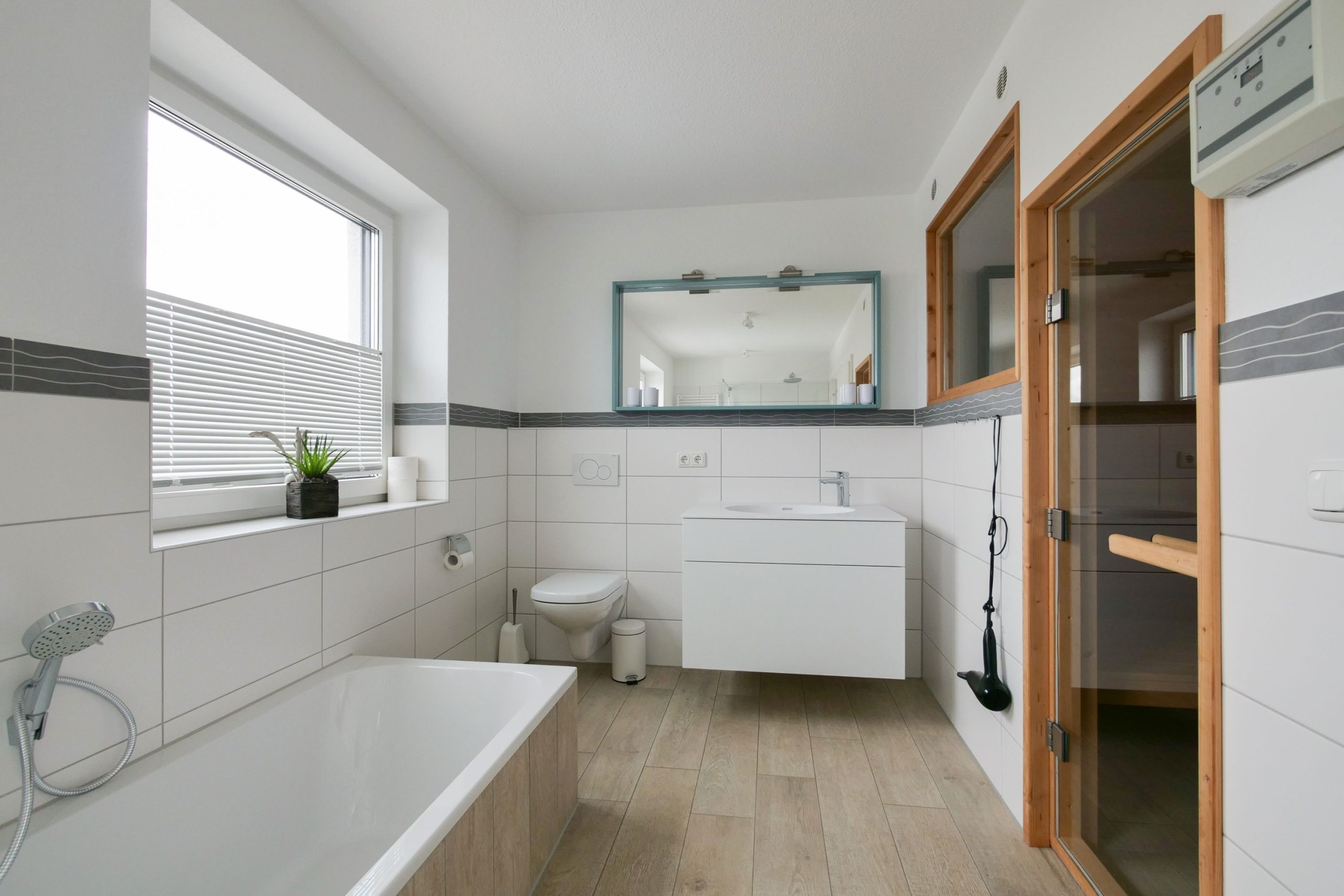Badezimmer mit Spiegel und Badewanne in Ferienhaus in Cuxhaven