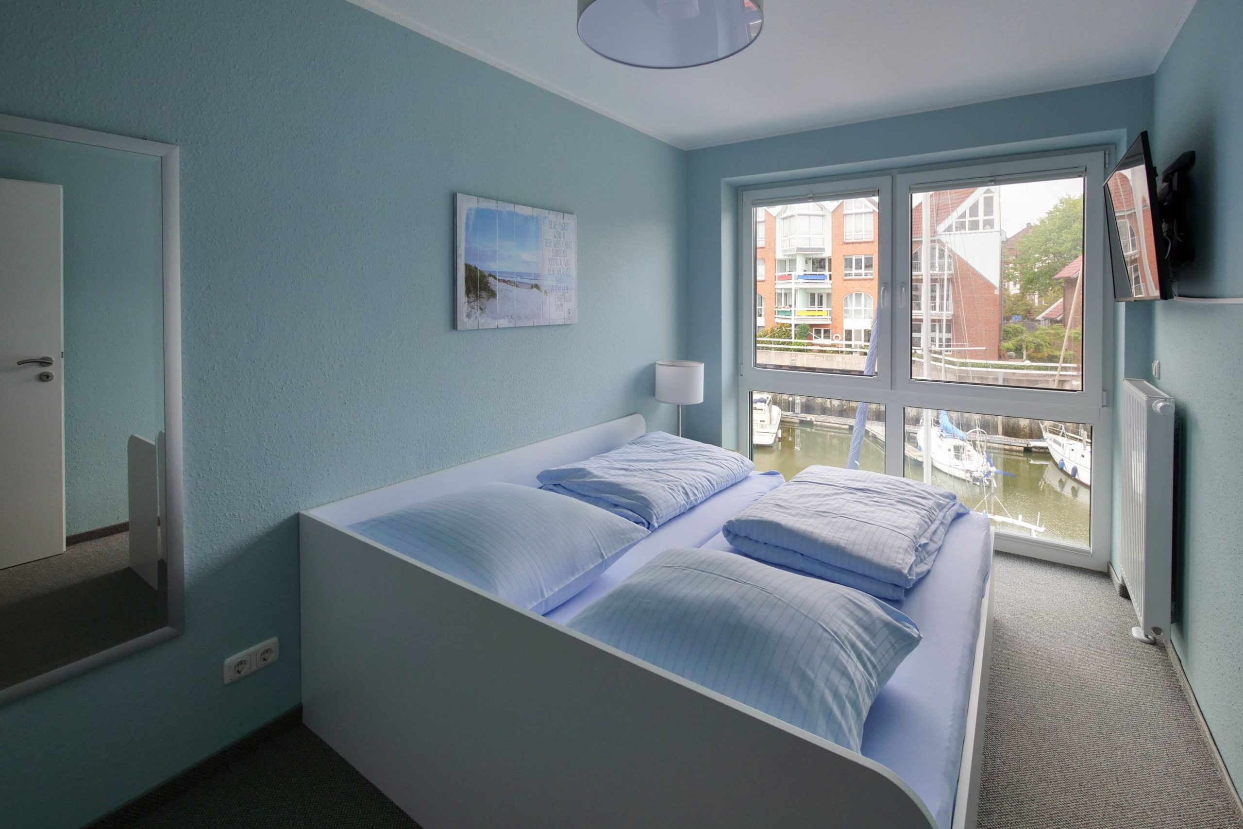 Doppelbett und Fernseher in Ferienhaus in Cuxhaven