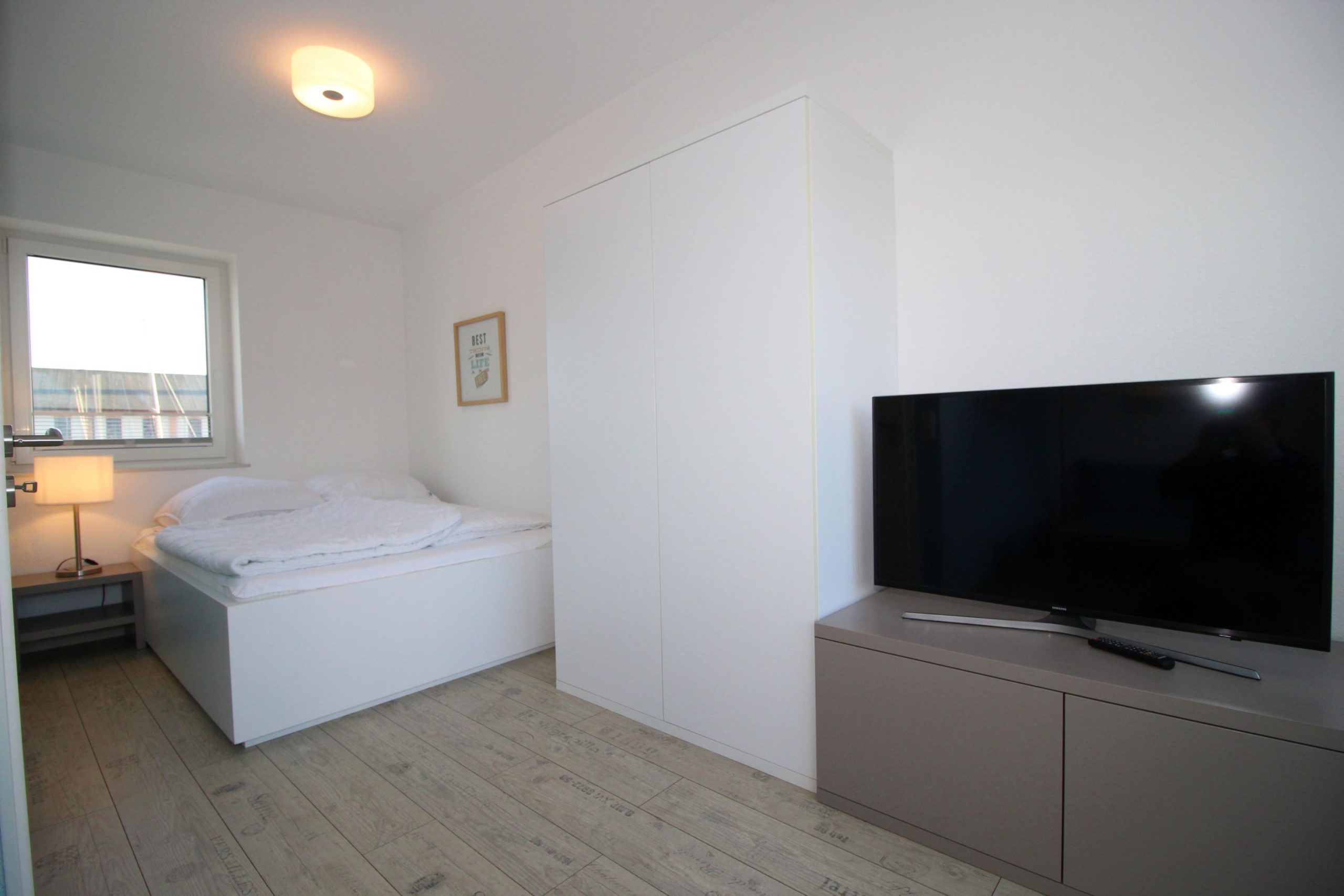 Doppelbett mit Kleiderschrank und Fernseher in Ferienhaus in Cuxhaven