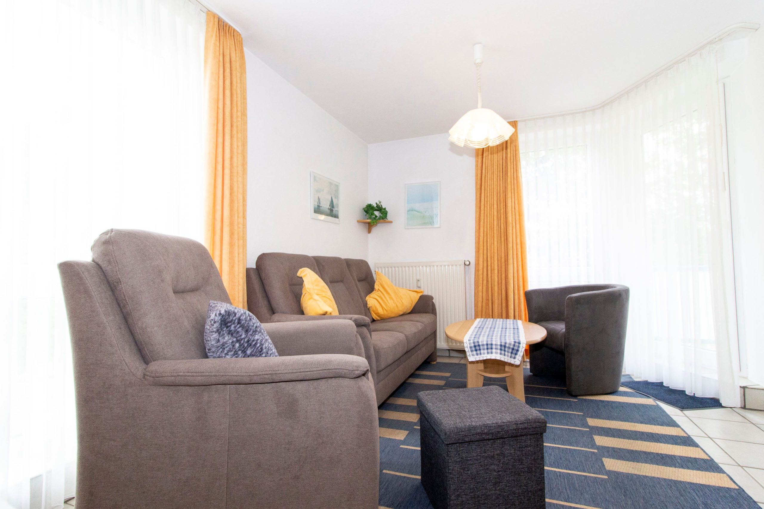 Wohnzimmer mit Sofa und Sessel in Ferienwohnung in Cuxhaven