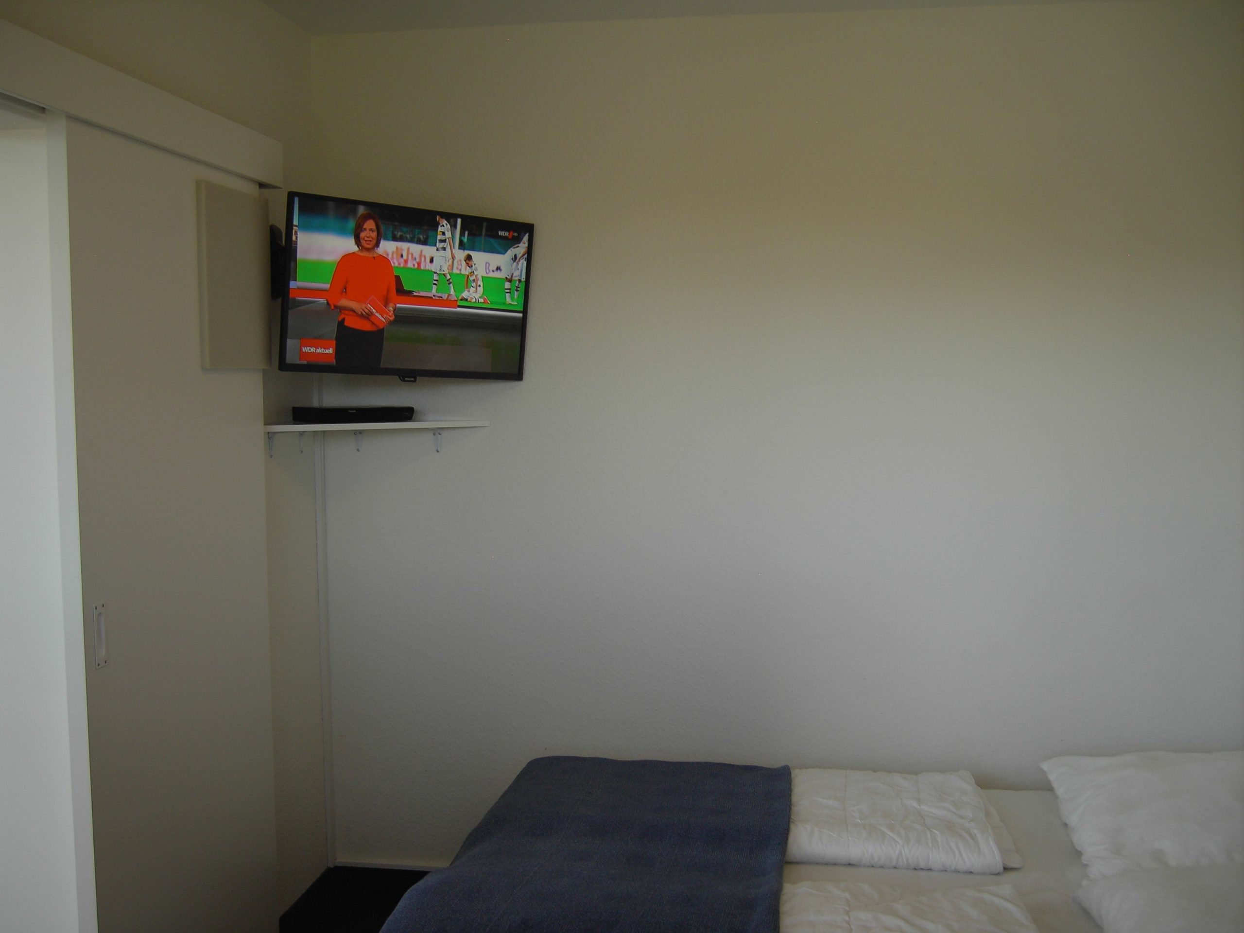 Schlafzimmer mit Fernseher und Doppelbett in Ferienwohnung in Cuxhaven