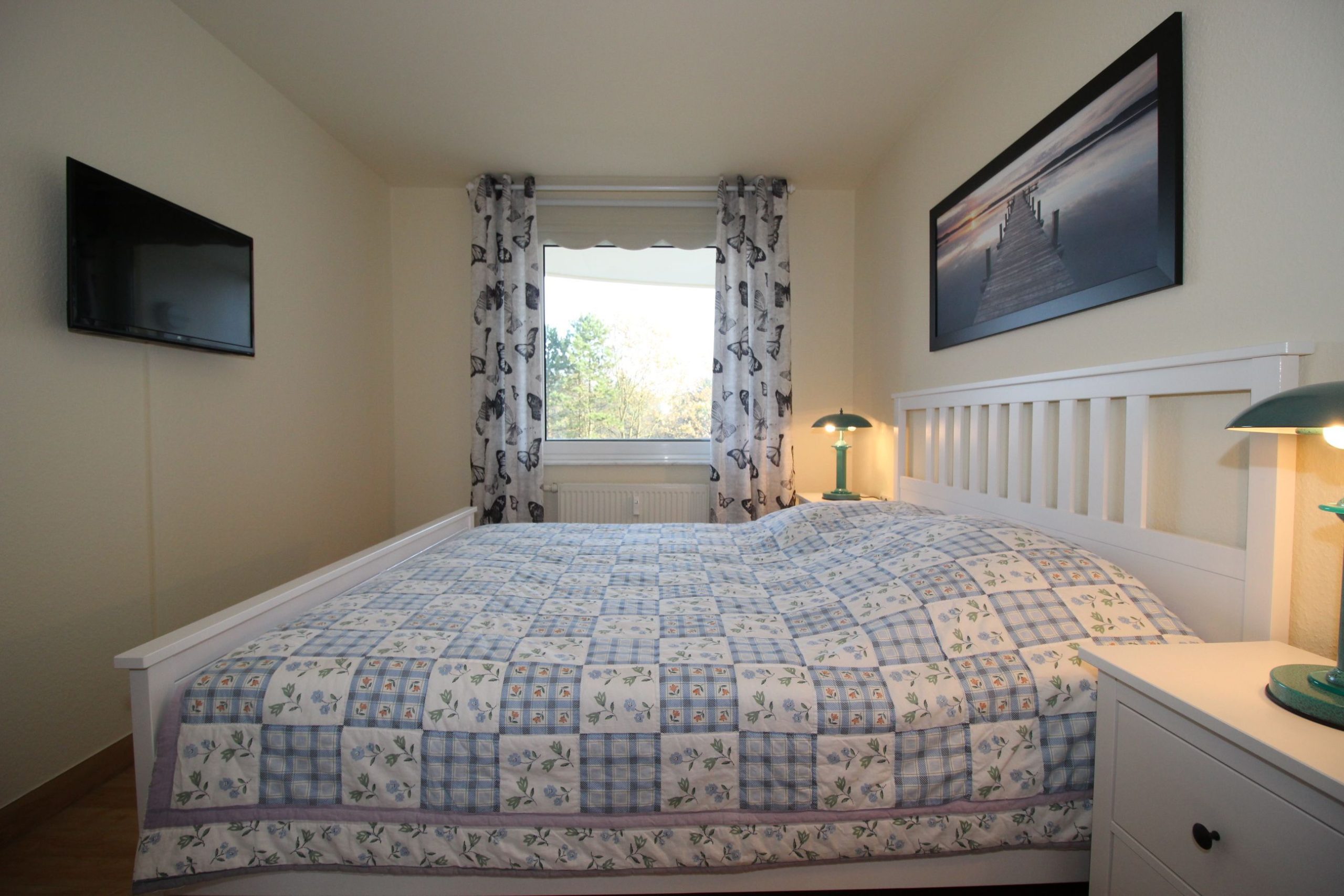 Schlafzimmer mit Doppelbett und Fernseher in Ferienwohnung in Cuxhaven